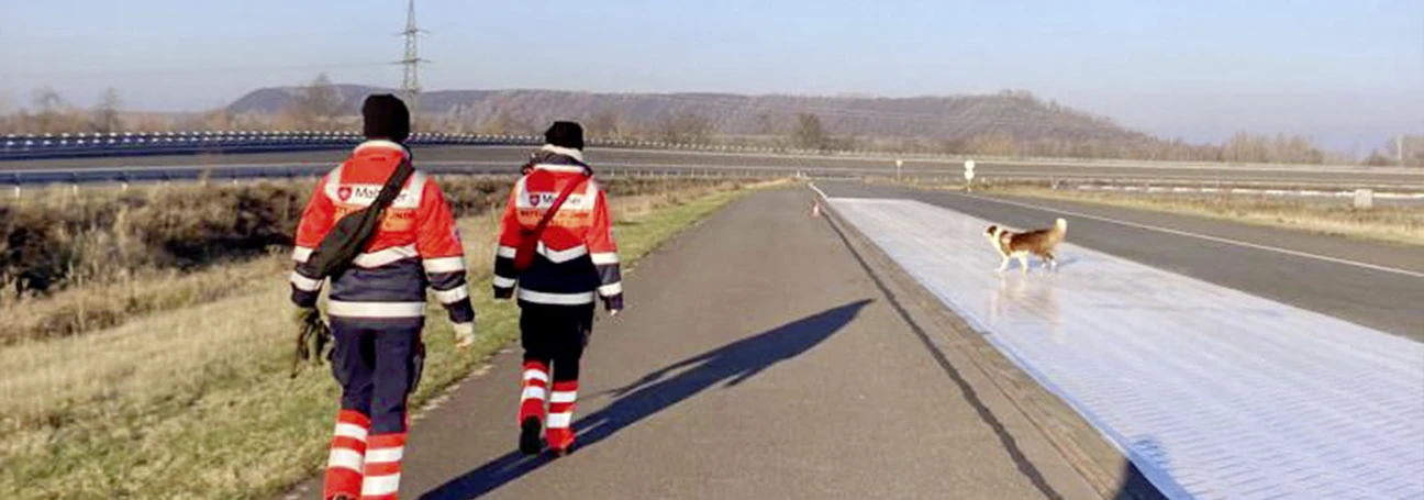 [[Photo: Rescue dog team on breaking test track]]