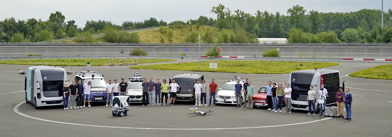 [Gruppenbild einiger Fahrzeuge aus dem Projekt mit den Ingenieur*innen]