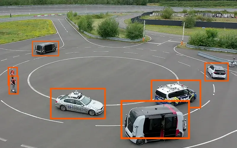 [Connected vehicles in a roundabout surrounded by vehicle detection]