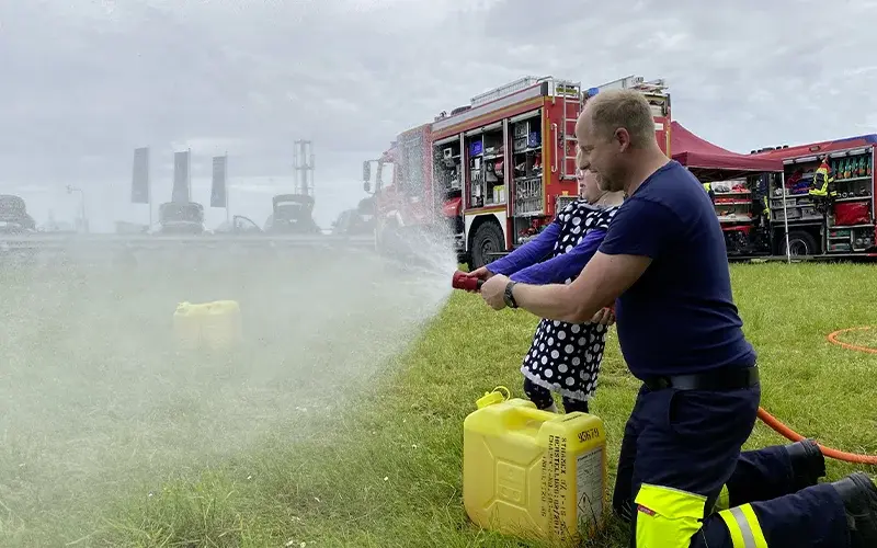 [Kind am Feuerwehrschlauch]