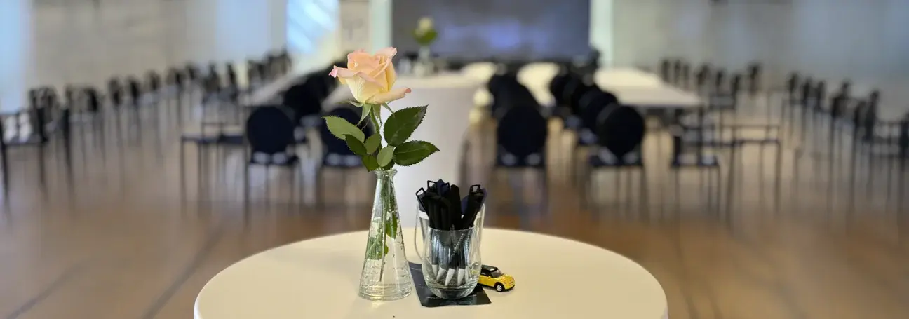 [Seminarraum Stehtisch mit Rose, Kugelschreiber, Spielzeugauto]